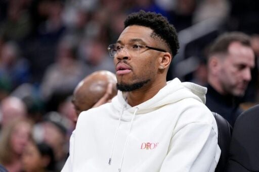 Milwaukee star Giannis Antetokounmpo, sidelined by a calf injury, watches from the bench as the Bucks post an NBA overtime win over the New Orleans Pelicans