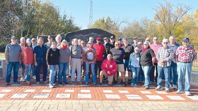 Retired railroad employees and Railroad Employees’ Memorial Committee members join Holiday Home Tour Committee members to celebrate the 2023 train-themed Get Healthy De Soto Holiday Home Tour, which will feature the memorial.