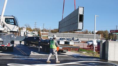 A Keeley Construction crew member loads the stop log onto a flatbed truck after floodwall testing on Nov. 6.