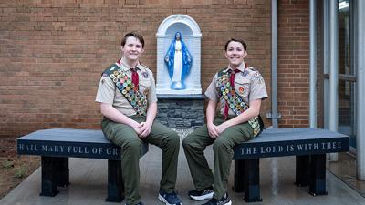 Evan Bailey, left, and Conner Bailey sit on the benches that Evan built. Conner made the stonework for the Virgin Mary statue.