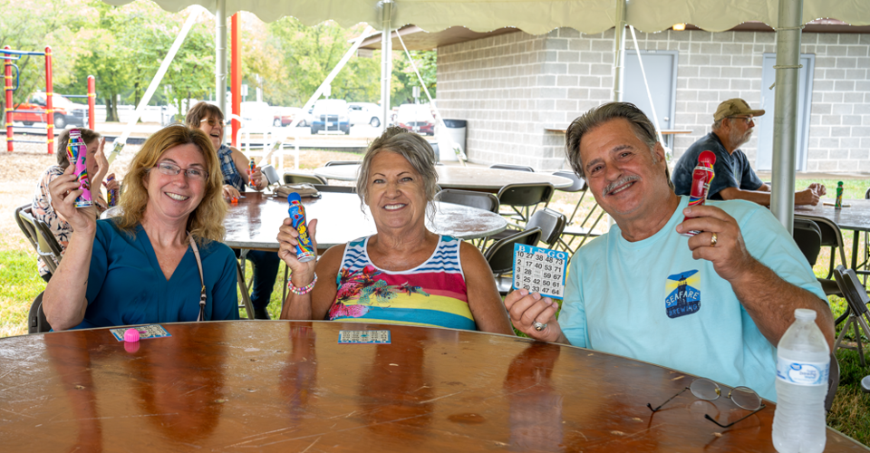 Gary and Paula House of Hillsboro and Priscilla Portell of Festus prepare for bingo at the Seniors in the Park event.