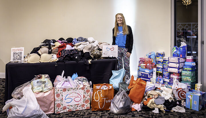 Deanna Heselbarth of Imperial, who started the St. Louis area chapter of I Support the Girls, stands with donations made to the organization at the Celebrating Women event.