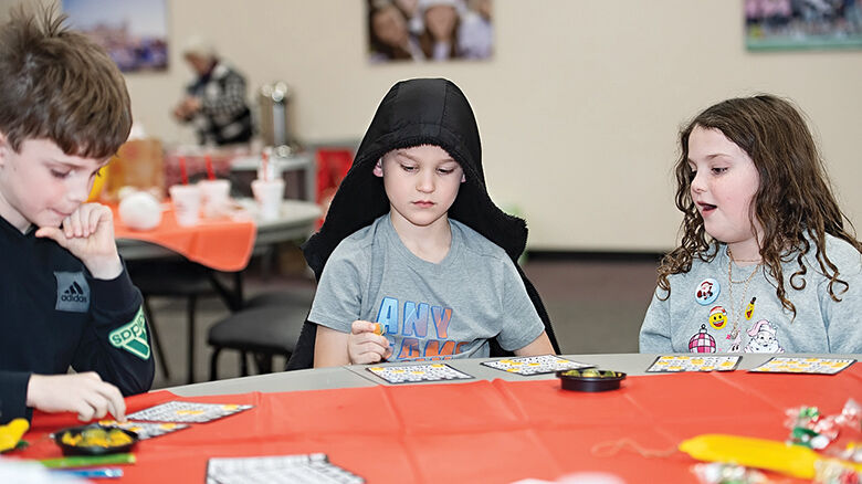 From left, Dean Harwood, 8, Ben Lenz, 8, and Vera Harwood, 8, of Imperial play a game of bingo.