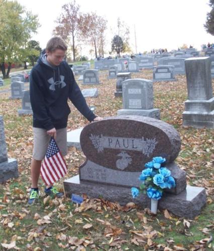 Elijah Schumer places flag on grave