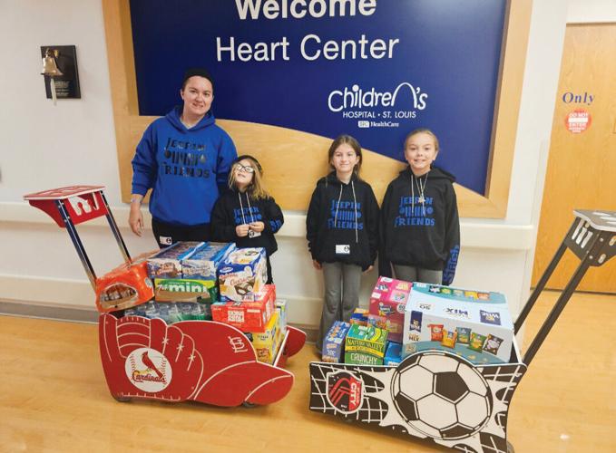 Amber White, left, with her daughters, Peyton, 7; Danielle, 9; and Emily, 10, delivering food for the snack room at St. Louis Children’s Hospital Heart Center.