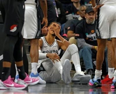 San Antonio Spurs star Victor Wembanyama holds his head after a hard fall in the NBA playoffs that left him with a concussion