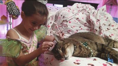 Brandy Schnitker of Fenton sent in this photo of her daughter, Kylie, playing with their late cat, Gizmo.