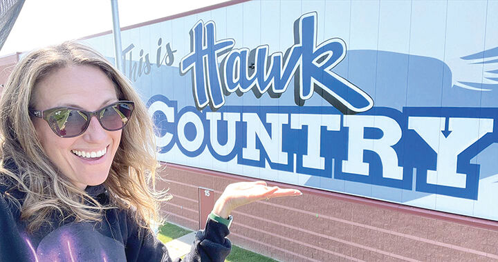 Artist Kenzie Wolk poses with the completed mural.