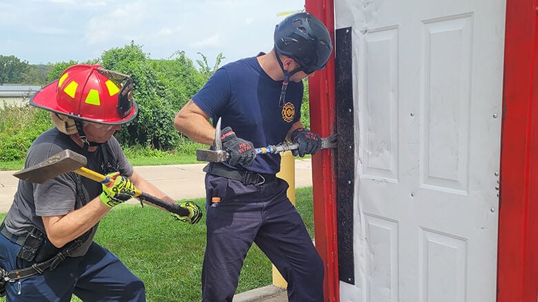 Saline Valley Fire Protection District Capt. Randy Gartner, left, and Firefighter Jim O’Neill work on forceable door entry.