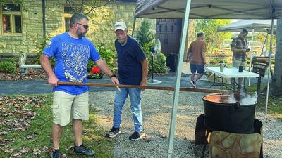 Church members make apple butter in a kettle in the church yard at the 2025 Grace Presbyterian Church Fall Festival.