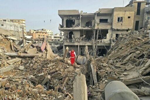 A rescue worker inspects the debris of destroyed buildings in the Maarakeh area near Lebanon's Tyre