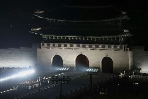 Members of K-pop boy group BTS stand on a stage during their concert at Gwanghwamun Square in Seoul on March 21, 2026