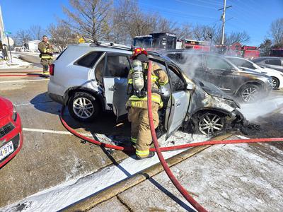 Firefighters extinguish vehicle fire in front of De Soto Junior High School