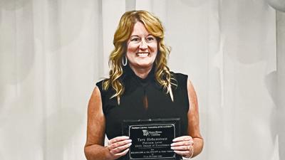 Tara Hebenstreit with an award for excellence as a Realtor.