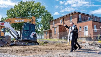 Archbishop Mitchell Rozanski blesses the site of the new Holy Family church during the parish’s groundbreaking ceremony.