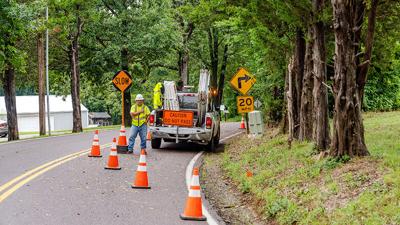 Workers set up cones at a curve on Johnson Road south of Festus.