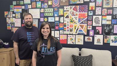 Atlas Youth Outreach executive directors Jeff Elden, left, and Annie Caputa have clients’ artwork on the wall in a lounge area in the organization’s new location at 1515 Astra Way in Arnold.