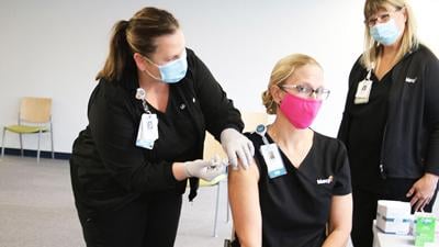 1091 Mercy Hospital Nurse clinician Jennifer Holt, 44, of Festus receives the first  COVID-19 vaccination in Jefferson County. Nurse clinician Tara Messer, 38, of Ware administers the first dose of the vaccine and Barb Vancil, 58, of Sullivan watches.