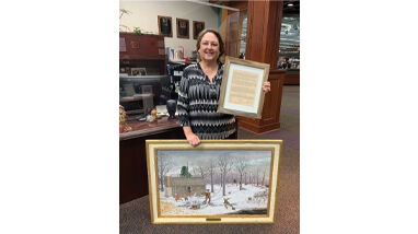 Mindy Hudson displays Eric Huff’s painting of the House Springs Massacre.
