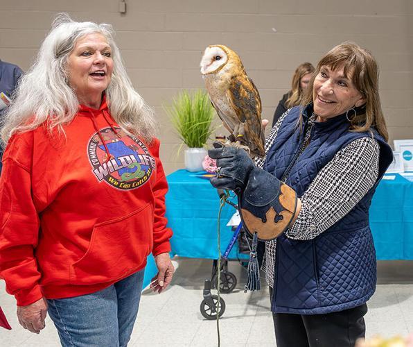 Judy Leitterman of De Soto, right, holds a rescued barn owl from the Wildlife Command Center where Robin Potter, left, volunteers.