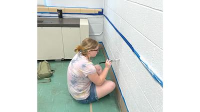 Izzy Brown, who will be a freshman, was among four girls painting the health room at De Soto High School.