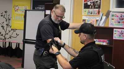 Herculaneum Police Officer Richard Reiber practices applying a tourniquet on Capt. Mark Grobe.
