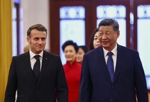 China's President Xi Jinping (R) and France's President Emmanuel Macron attend a welcome ceremony at the Great Hall of the People in Beijing
