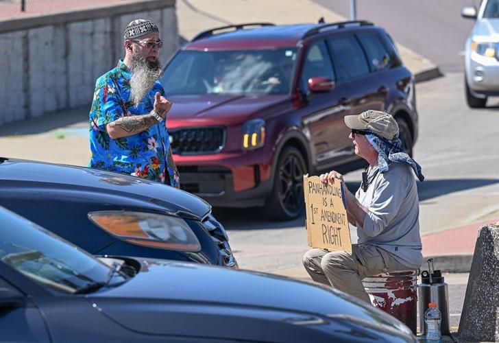 Drew McCausland, left, talks to Dirk Burhans in the median as traffic drives
