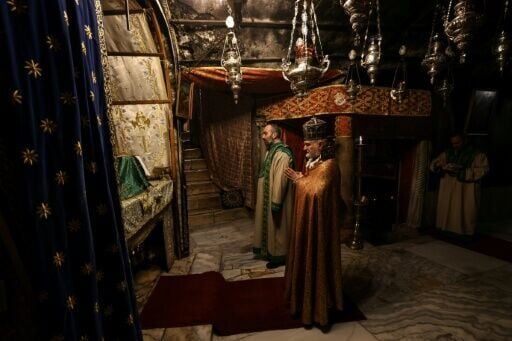 Members of the clergy pray inside the Grotto, believed to be the birthplace of Jesus Christ, in the Church of the Nativity in Bethlehem