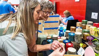 Angie Svoboda of Barnhart, front, and her mother, Donna Light of Arnold, look through Modera Crafters’ miniature figures on March 7 at the Fox High School Spring Craft Fair in Arnold.