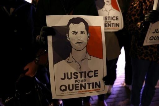 A demonstrator in the northern city of Lille holds a portrait during a rally in tribute to Quentin Deranque