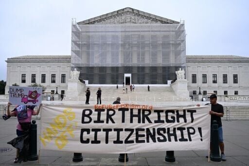 Demonstrators hold a banner outside the US Supreme Court during a June 27, 2025 protest