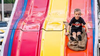 Kai Alley, 4, of Hillsboro goes down the giant slide at the Hillsboro Homecoming Festival.