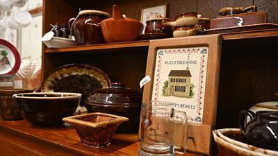 Antique home goods sit on a hutch on Wednesday, May 27, at Under the Tree in Festus. Vendors were working to get items moved in, priced and arranged before the new space opens on June 6.