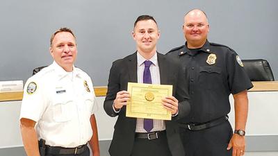 Arnold Police Chief Brian Carroll, left, Brett Miller and Maj. Clinton Wooldridge on June 28 at Arnold City Hall when Miller was sworn in as an Arnold Police officer.