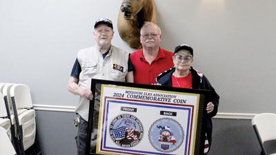 From left, Cedar Hill Elks members Don Mattingly, John Devous and Miky Balta stand with the design for a commemorative coin that will be sold to Elks members and veterans across Missouri this year.