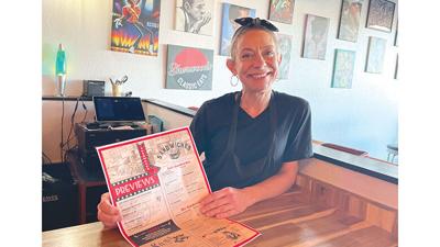 Owner Tiffany Lindsey of Arnold holds up Sherwoods Classic Eats’ new menu.