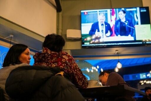 Residents watch a press conference of Greenland's Foreign Minister Vivian Motzfeldt and Denmark's Foreign Minister Lars Loekke Rasmussen in Nuuk after a meeting over the future of the island held in Washington