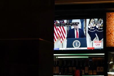 A TV displays U.S. President Donald Trump's prime-time address on the war in Iran inside a Cheesecake Factory on April 1, 2026, in Washington, D.C.