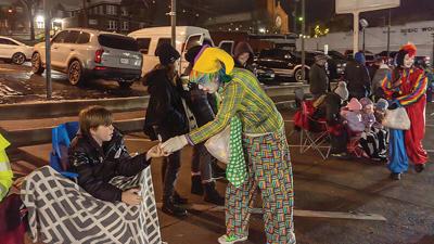 Corky McCoy of Festus hands out candy as a KC Clown at the Twin City Area Chamber of Commerce Christmas Parade.