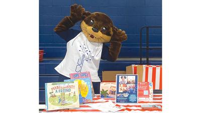 Oliver poses with some of the books available at the Jefferson County Library.