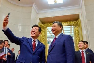 South Korea's President Lee Jae Myung (L) takes a selfie with China's President Xi Jinping (R) after a dinner at the Great Hall of the People in Beijing on January 5, 2026