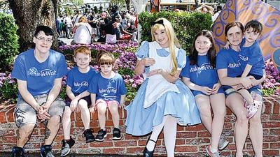 The Cordova family poses with Alice in Wonderland during a Make-a-Wish trip to Walt Disney World in 2017.