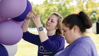 Hannah Jones attaches cards with memories of her mother, Amanda Jones, to helium-filled balloons.