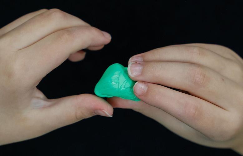 Carter rolls green putty while working with a deaf educator