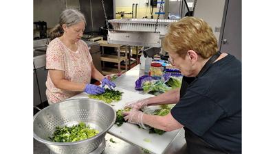 The James II Project volunteers Peggy Walker, left, and Cathy Larue prepare food for the organization’s first meal at St. Anthony of Padua Catholic Church, 3008 High Ridge Blvd., in High Ridge on June 2.