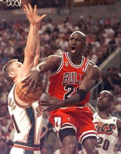 Chicago Bulls Michael Jordan (23) makes a pass around Detlef Schrempf (L) of the Seattle SuperSonics.
