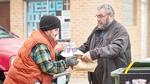 Tommy Marler, left, receives a meal from Jim McGuire of New Hope Fellowship Church.