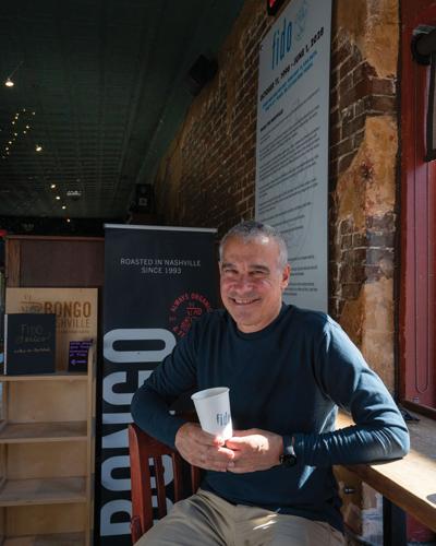 Bob Bernstein sitting at Fido, holding a cup