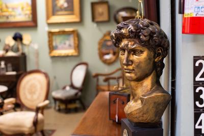 A copper bust, chairs, and framed art at GasLamp Antiques